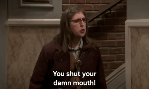 Woman in Glasses in Front of Brick Wall Says You Shut Your Damn Mouth