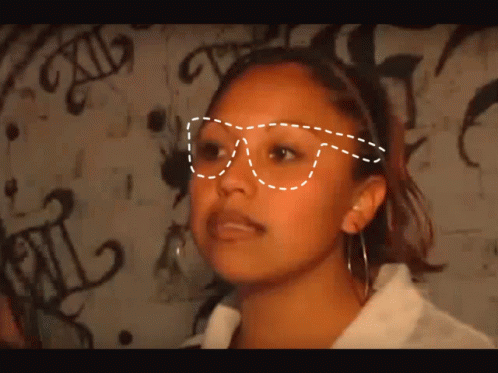 Woman In Glasses In Front Of Graffiti Saying XII GIF