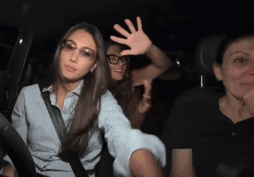 Woman in Glasses Raising Hand