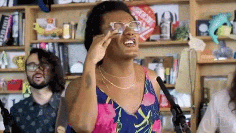 Woman in Glasses Singing into Microphone
