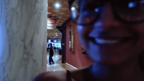 Woman In Glasses Smiling At Exit Sign GIF
