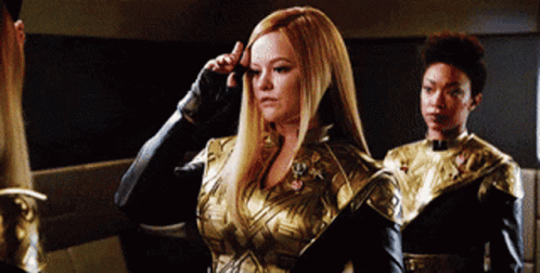 Woman in Gold and Black Outfit Next to Woman