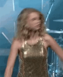 Woman in Gold Dress Dancing on Stage
