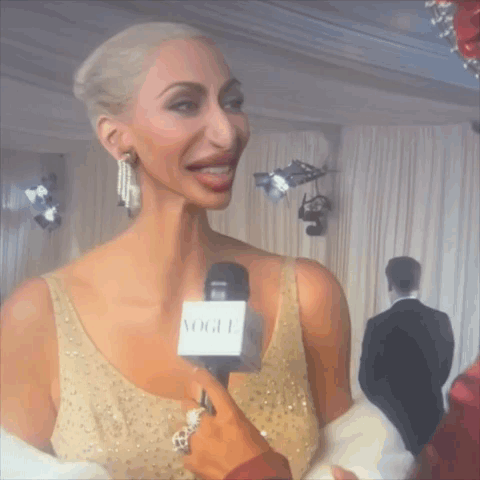 Woman in Gold Dress Interviewed with Vogue Microphone