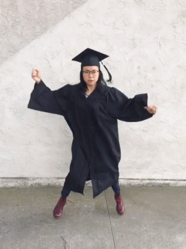 Woman In Graduation Cap And Gown Flexing GIF