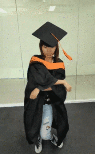 Woman in Graduation Cap and Gown Kneeling