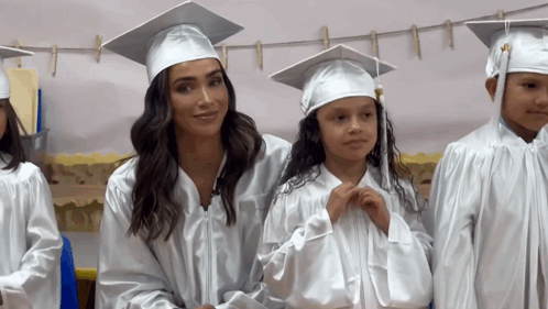 Woman in Graduation Cap and Gown Next to Girl