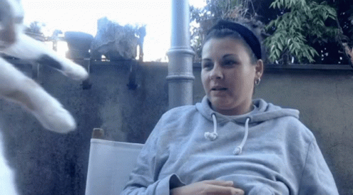 Woman in Gray Hoodie Sitting in Chair