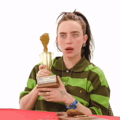 Woman In Green And Brown Striped Shirt Holding Winner Trophy GIF