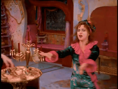 Woman In Green And Pink Dress Dancing By Candelabra GIF