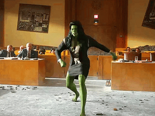 Woman in Green Dress Dancing Before Suited Group