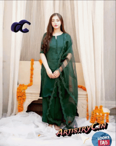 Woman in Green Dress in Front of Couch With Flowers