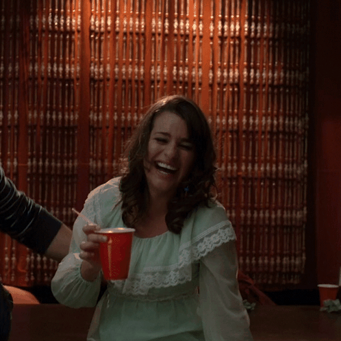 Woman in Green Dress Laughing With Red Cup