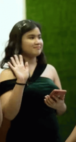 Woman in Green Dress Waving Holding Cell Phone