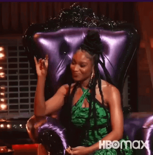 Woman in Green Dress Waving in Purple Chair