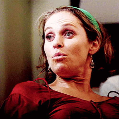 Woman in Green Headband and Earrings Making a Face