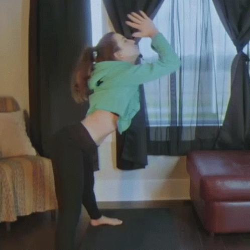 Woman in Green Hoodie and Black Pants at Window