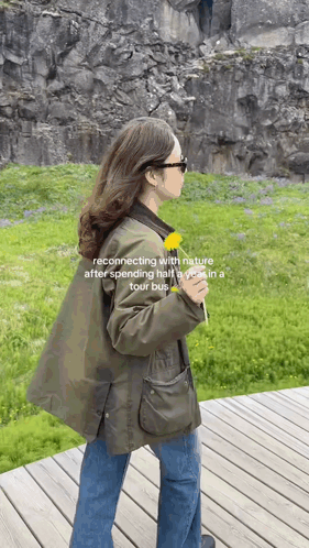 Woman in Green Jacket Holding Dandelion