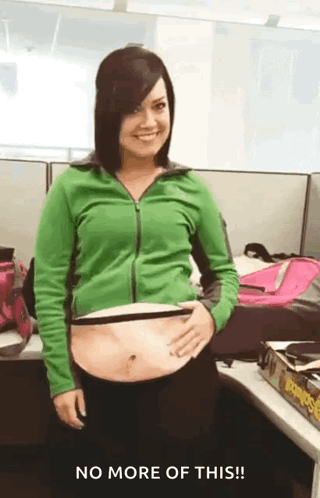 Woman in Green Jacket Holding Stomach No More