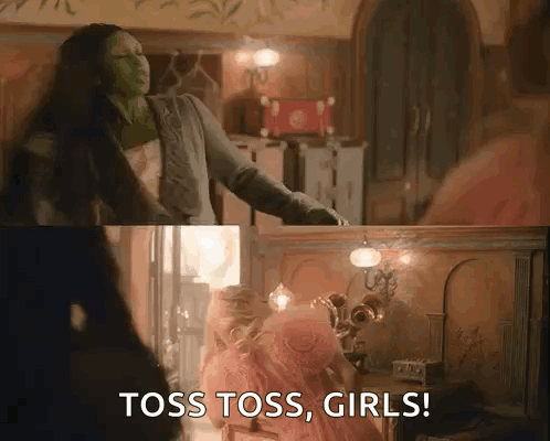 Woman In Green Mask Saying Toss Toss Girls Beside Pink Dress Girl GIF