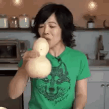 Woman in Green Shirt Blowing Balloon