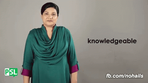 Woman in Green Shirt in Front of Sign Saying Knowledgeable