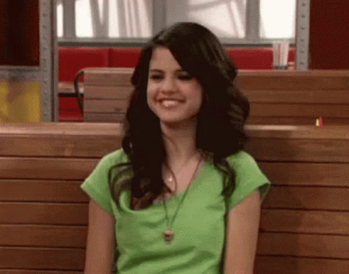 Woman In Green Shirt Smiling On Wooden Bench In Restaurant GIF