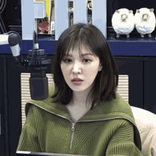 Woman in Green Sweater at Microphone