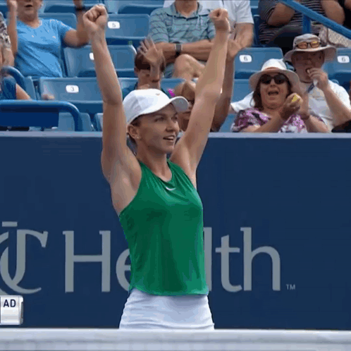 Woman in Green Tank Top and White Skirt Arms Raised