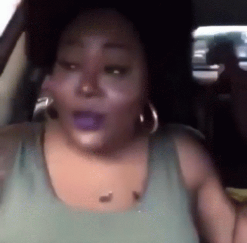 Woman in Green Tank Top Sitting in Car With Mouth Open