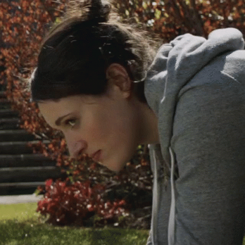 Woman in Grey Hoodie Looking Down at Camera