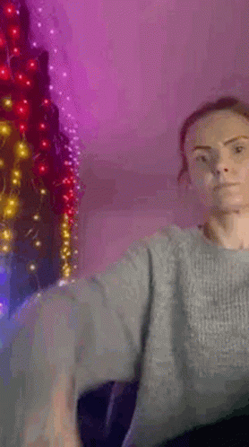 Woman in Grey Sweater by Christmas Tree With Lights