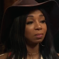Woman In Hat And Earrings Looking At Camera GIF