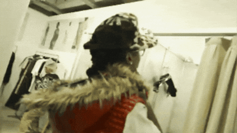 Woman In Hat And Fur Vest In Dressing Room GIF