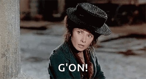 Woman In Hat And Jacket By Wall Saying G'on GIF