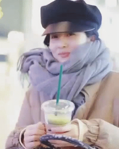Woman in Hat and Scarf Holding Coffee with Straw