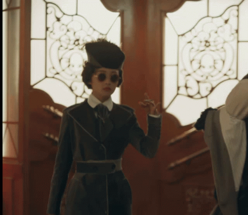 Woman in Hat and Sunglasses at Door