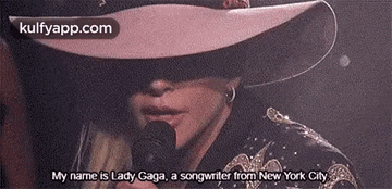 Woman in Hat and Sunglasses Holding Microphone
