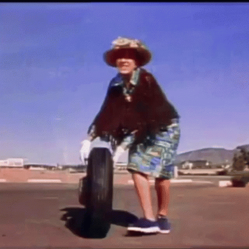 Woman in Hat Standing Next to Tire
