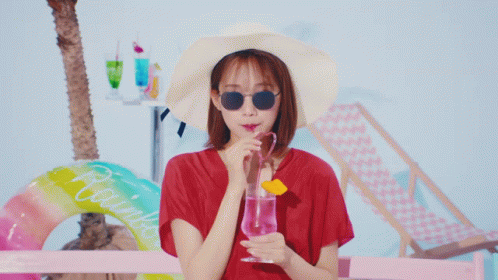 Woman in Hat Sunglasses Drinking Pink Glass
