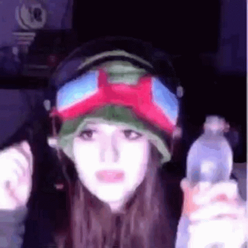 Woman in Headphones and Goggles Holding Water Bottle