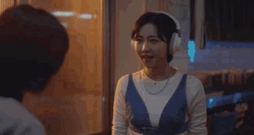 Woman in Headphones Talks to Woman Woo to Young to Woo