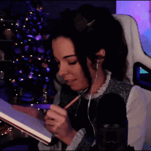 Woman in Headphones Writing in Book