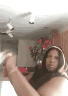 Woman in Hoodie Taking Selfie in Kitchen With Flowers