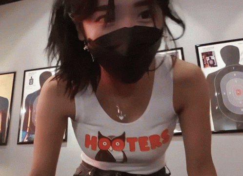 Woman In Hooters Shirt And Black Mask GIF