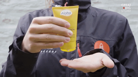 Woman In Jacket Rubbing Lotion On Face GIF
