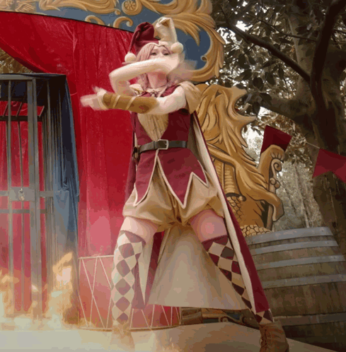 Woman in Jester Costume in Front of Fire Barrel