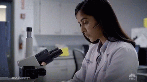 Woman In Lab Coat At Microscope With NBC Logo GIF