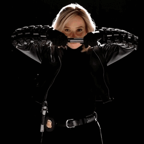 Woman in Leather Jacket Holding Gun