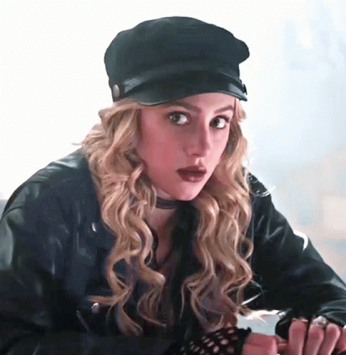 Woman In Leather Jacket Looking At Camera In Dark Room GIF